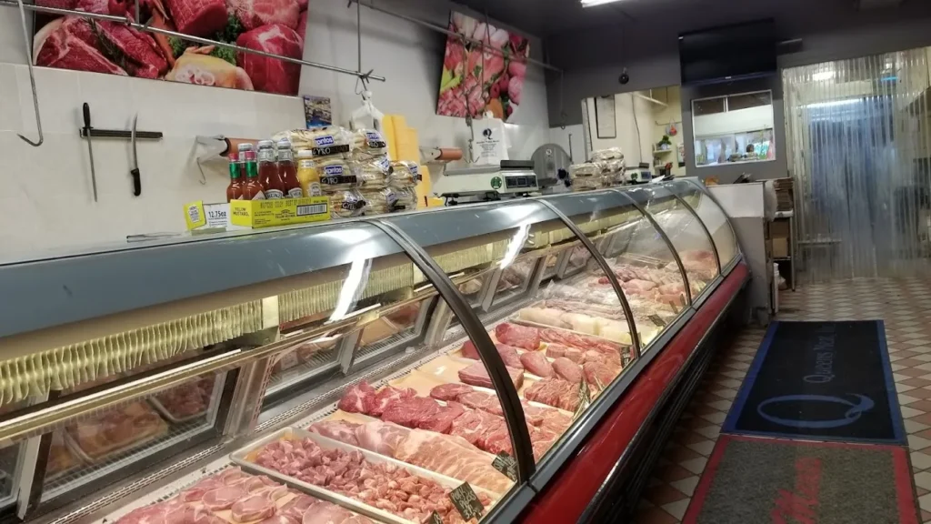 Meat display counter in a butcher shop with various cuts of meat.
